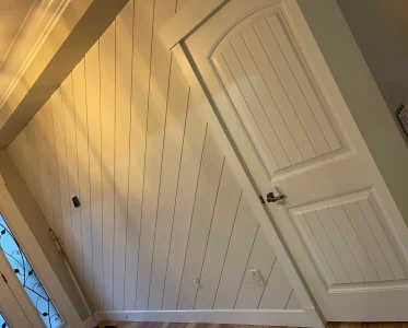Open white door with window, leading to a hallway